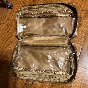 Bronze colored, cosmetic or jewelry bag with double handles and zipper.